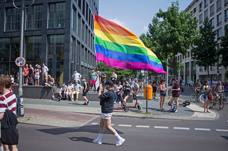 Male demonstrator gracefully holding big rainbow flag during Christopher Street Day / Gay Pride Berlin 2021.
Männlicher Demonstrant hält anmutig eine große Regenbogenfahne während des Christopher Street Day / Gay Pride Berlin 2021.