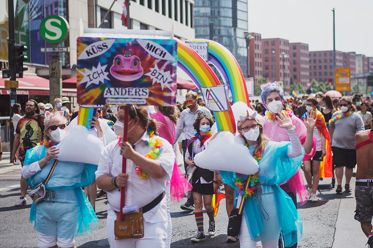 Colorful protestors marching and waving at photographer during Christopher Street Day / Gay Pride Berlin 2021.
Bunte Demonstrant:innen marschieren und winken der Fotografin während des Christopher Street Day / Gay Pride Berlin 2021 zu.