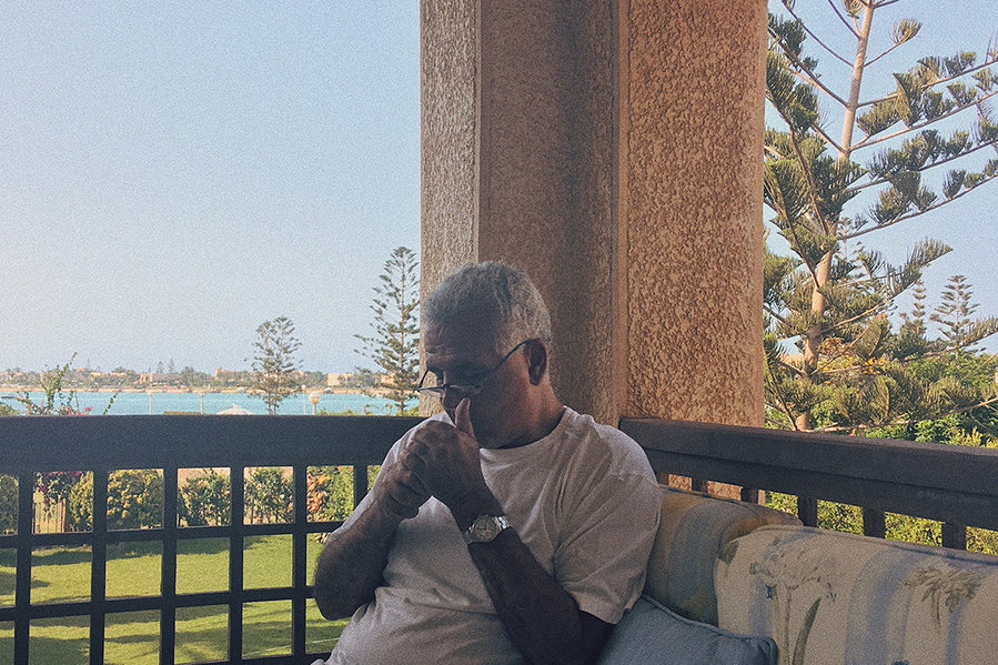 Analog photograph of man lighting a cigarette, taken with iPhone SE (1st gen)