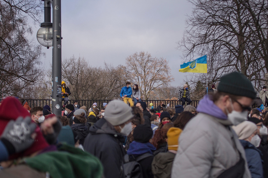 Demonstrierende sitzen auf einem Zaun auf der Friedensdemo gegen den Ukraine-Krieg in Berlin am 27.02. 