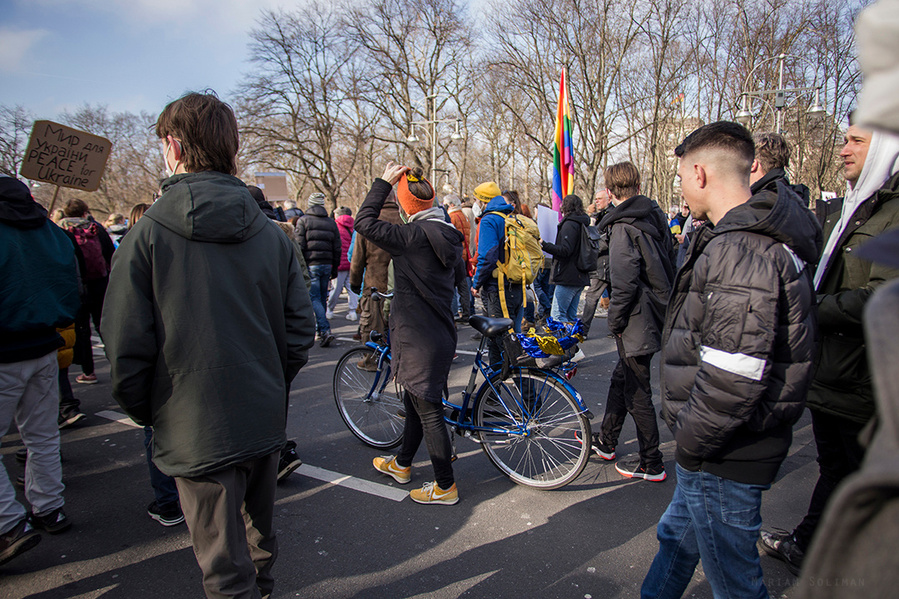 Teilnehmerin mit blau-gelb geschmücktem Fahrrad auf der Friedensdemo gegen den Ukraine-Krieg in Berlin am 27.02. 