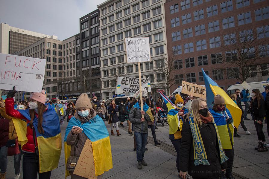 Demonstrierende mit Schild und ukrainischen Flaggen auf Friedensdemo am 27.02.22 in Berlin bei der Friedrichstraße 