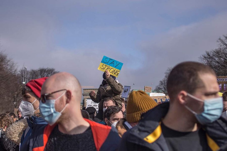Kind hält Schild mit dem Text Stay Strong auf der Friedensdemo gegen den Ukraine-Krieg in Berlin am 27.02. 