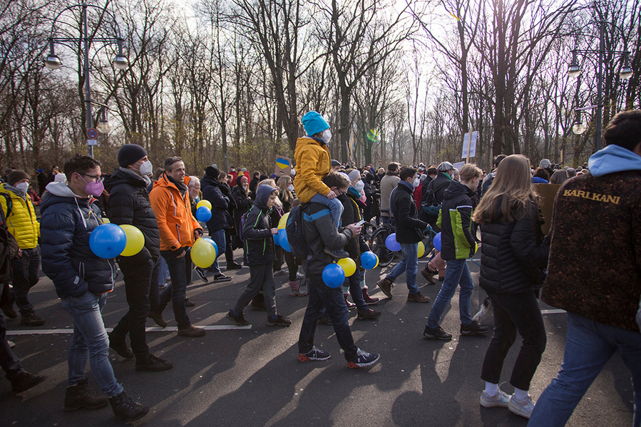 Demonstrierende mit blauen und gelben Ballons auf der Friedensdemo gegen den Ukraine-Krieg in Berlin am 27.02. 