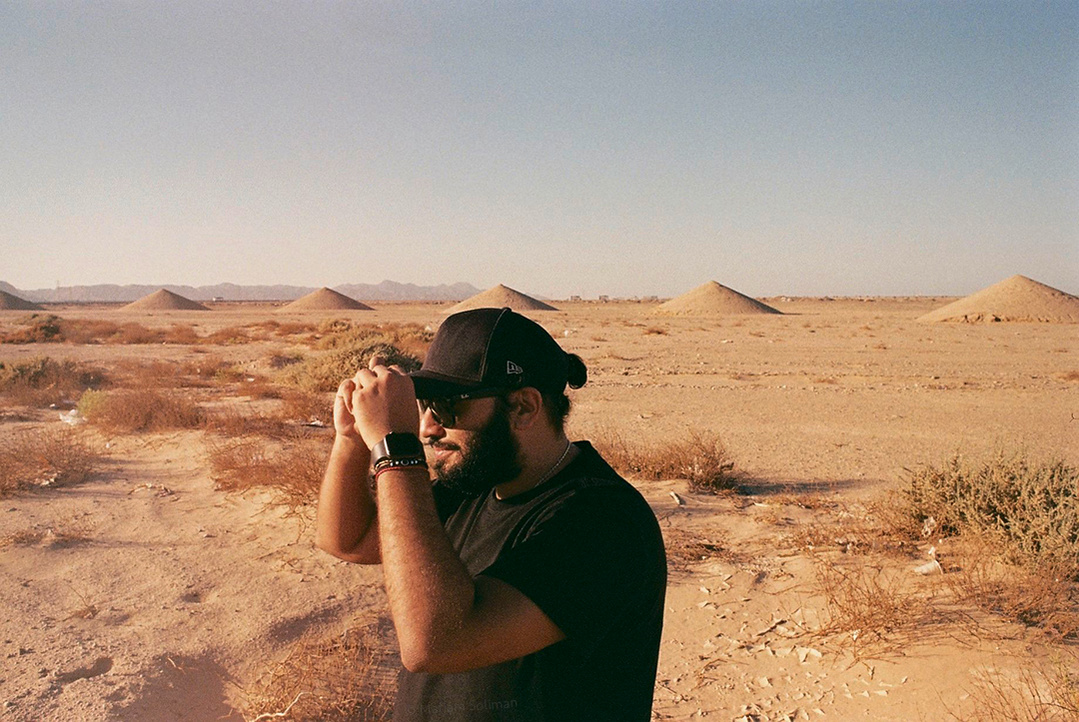 Analog photograph of young man with black apparel in the desert
