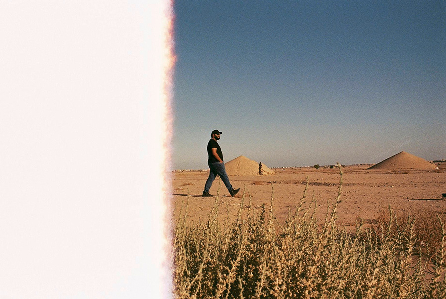 Analog photograph of young man in the desert with light leak