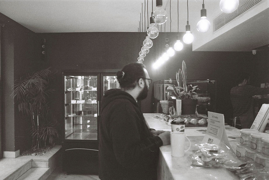 Black and white analog photograph of young man in a bakery shop in Zamalek in Cairo