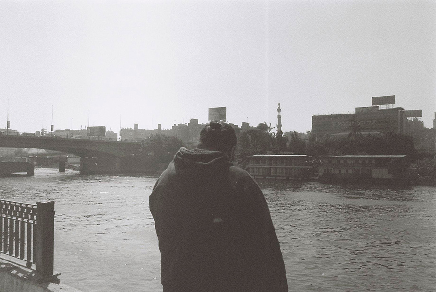 Black and white analog photograph of young man looking at the Nile in Zamalek in Cairo