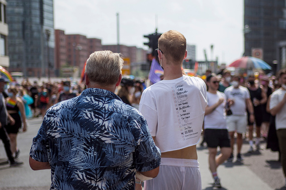 Two men watching passing crowd during Christopher Street Day / Gay Pride Berlin 2021.
Zwei Männer beobachten die vorbeiziehende Menschenmenge während des Christopher Street Day / Gay Pride Berlin 2021.