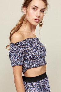 photo model in in crop-top and shorts on plain background