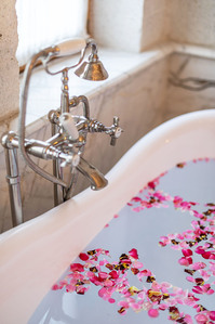 bathroom interior freestanding bathtub with pink flowers on water