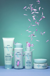 cosmetic hair products set on turquoise background with falling flower leaves
