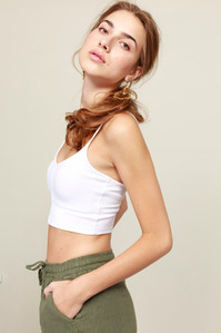 photo model in in crop-top and shorts on plain background
