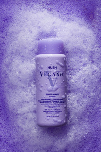purple shampoo bottle on purple background with bubbles