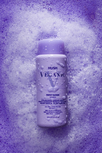 purple shampoo bottle on purple background with bubbles