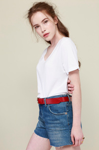 model with white t-shirt and denim shorts on plain background
