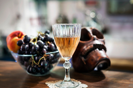 a glass of vine and a plate grapes with skull