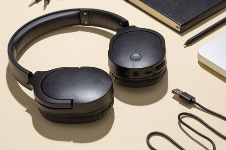 headphones on yellow background with laptop, cables and notebook