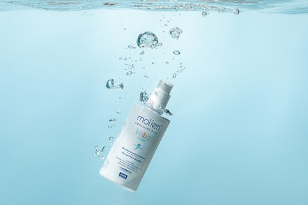 cosmetic baby lotion product on light blue background with bubbles underwater