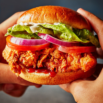 A handheld chicken burger , perfect for editorial and restaurant food photography, shot by food photographer, Sid Ali