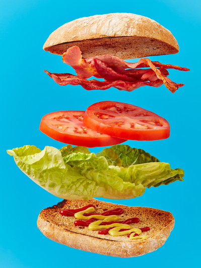floating blt burger against bright blue background, perfect for editorial, advertising and restaurant food photography, shot by food photographer, Sid Ali