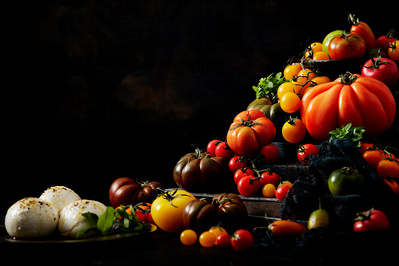 A stack of beautiful tomatoes shot on dark background, perfect for editorial and restaurant food photography, shot by food photographer, Sid Ali