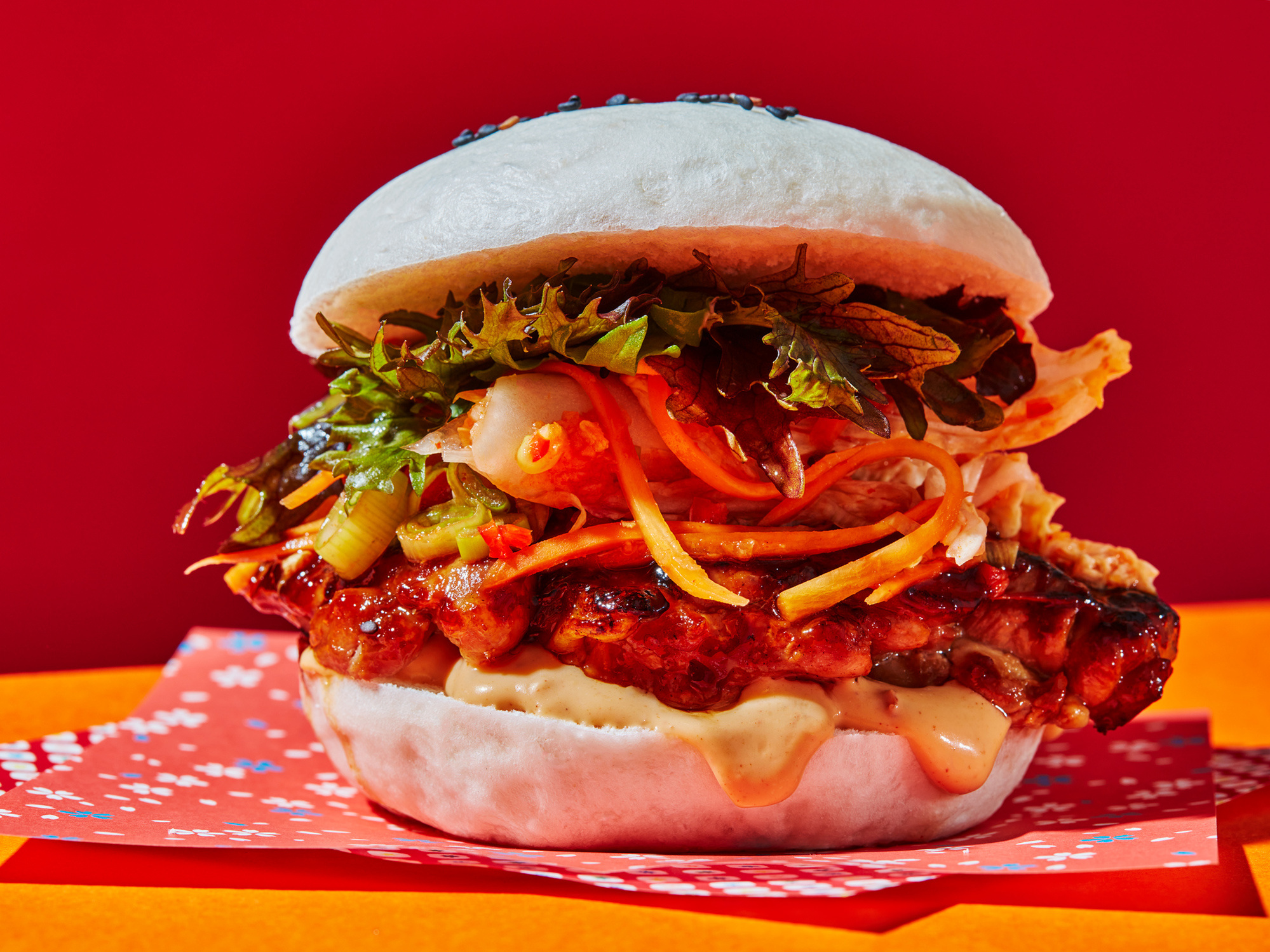 Graphic korean chicken and kimchi burger food photography with hard shadows shot by leading london food photographer sid ali