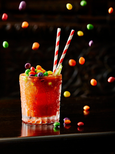 a skittle cocktail with flying skittles, perfect for editorial, advertising and restaurant food photography, shot by food photographer, Sid Ali