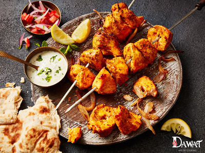 skewers of chicken tikka shot on dark background, with naan bread and salad perfect for editorial and restaurant food photography, shot by food photographer, Sid Ali