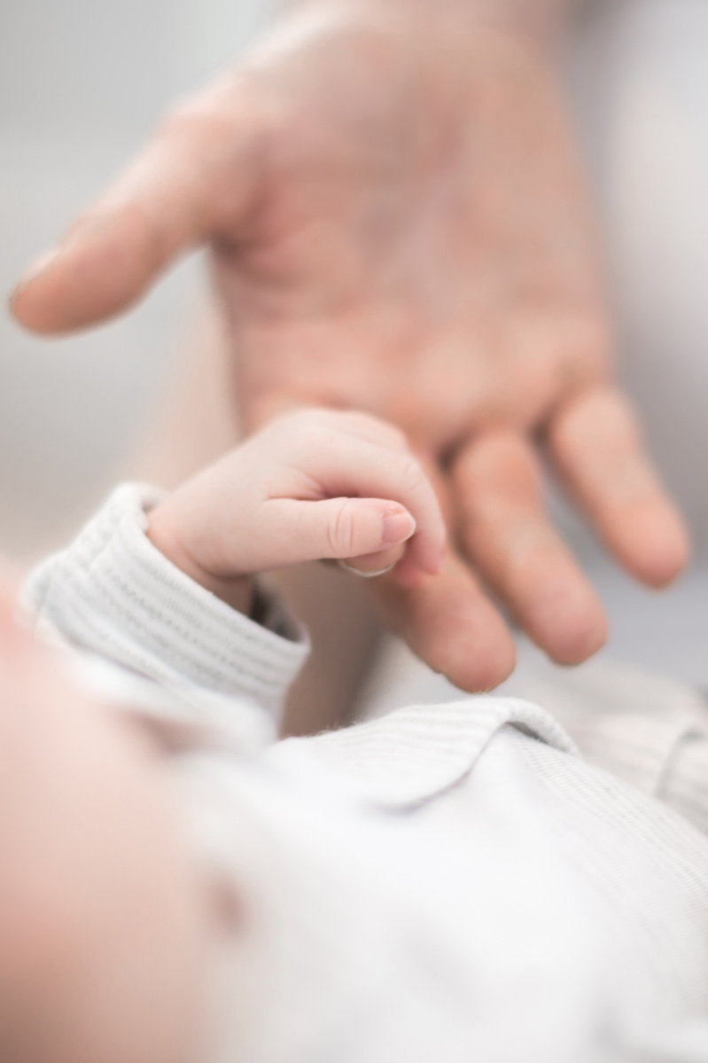 parent holding hand of newborn baby