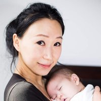 family mother holding newborn baby in their home