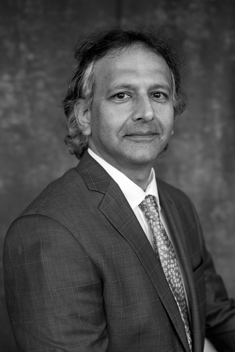 Headshot of a CEO wearing a suit with  against a studio background