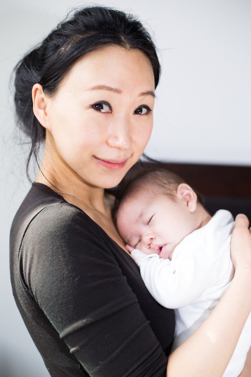 family mother holding newborn baby in their home