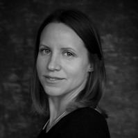 Award winning black and white portrait of a brunette woman against a grey photography studio backdrop