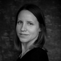 Award winning black and white portrait of a brunette woman against a grey photography studio backdrop