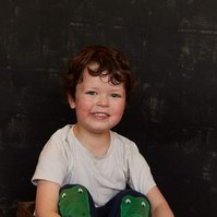 Toddler boy in studio with black backdrop