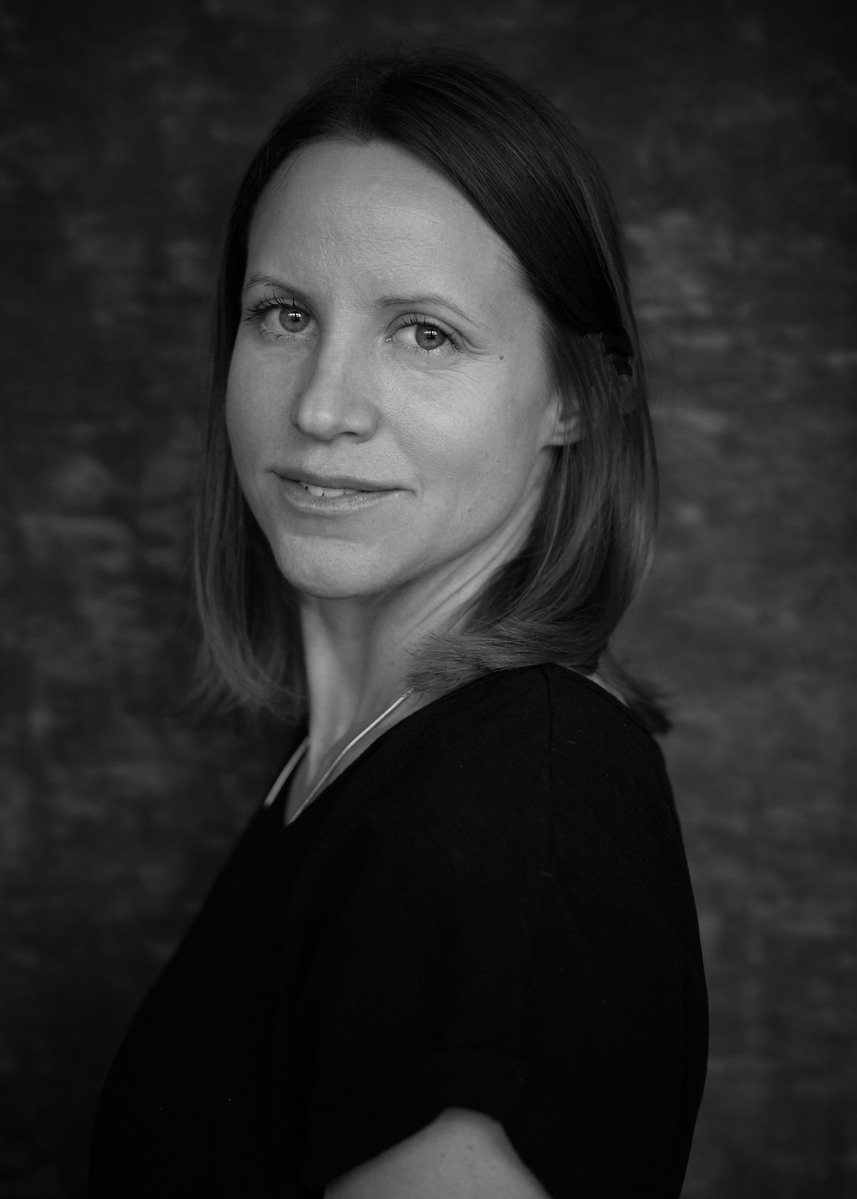 Award winning black and white portrait of a brunette woman against a grey photography studio backdrop