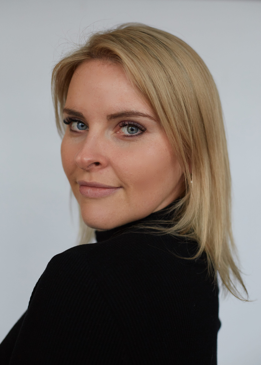 Professional photography studio portrait of a blonde woman against grey backdrop  