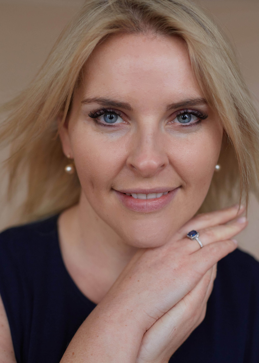 close-up studio portrait of a blonde woman against neutral backdrop  