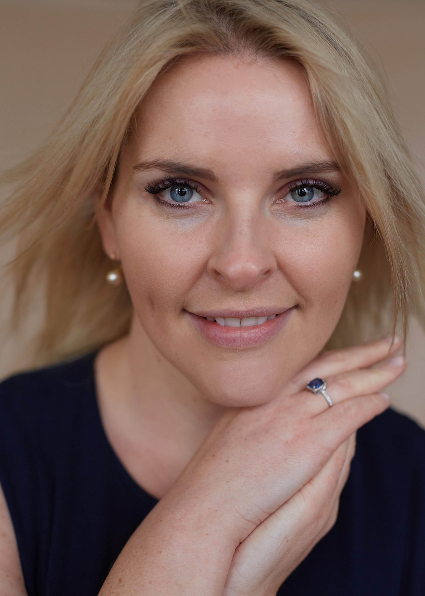 close-up studio portrait of a blonde woman against neutral backdrop  