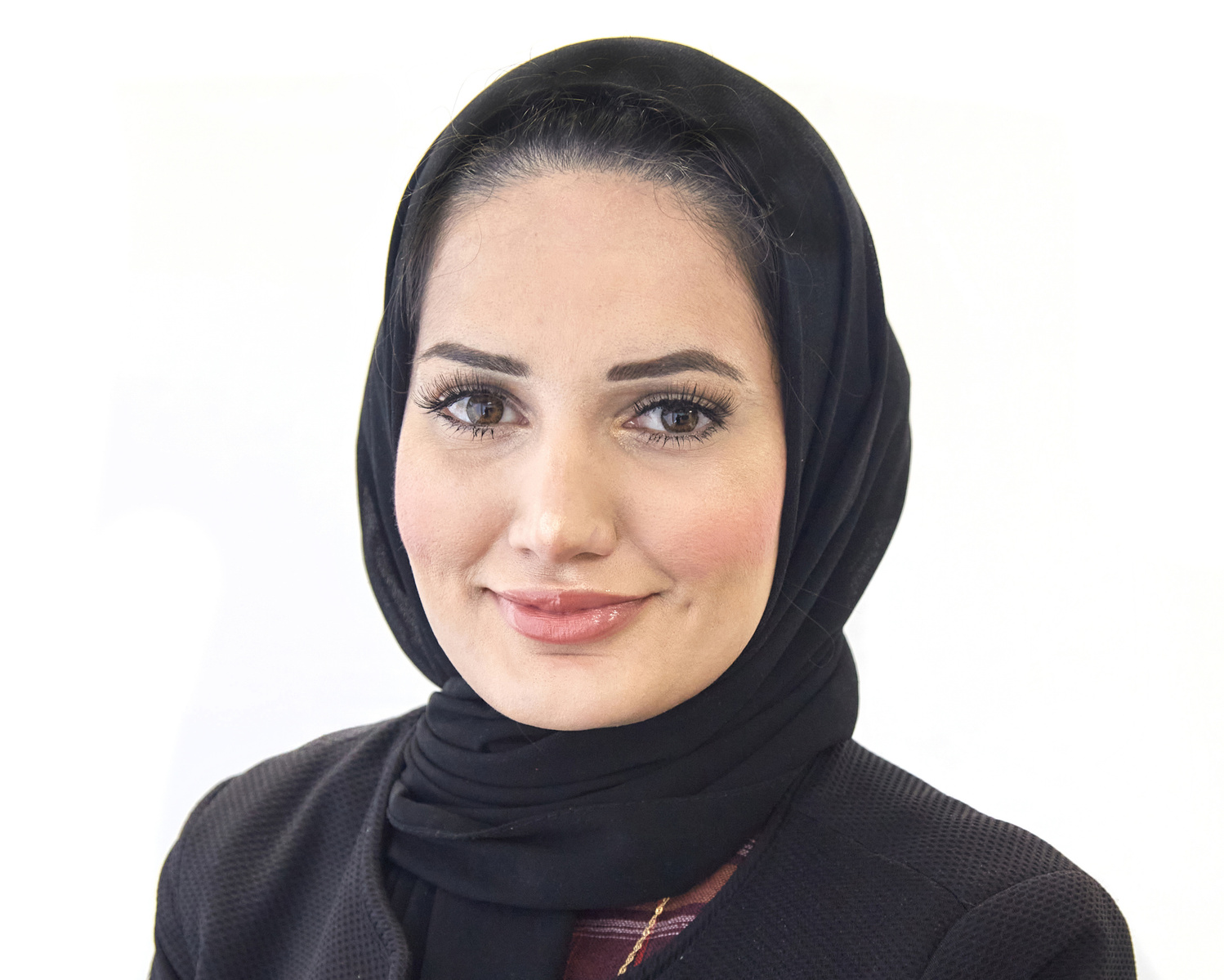 Professional Headshot of a woman wearing a black hijab against a white background