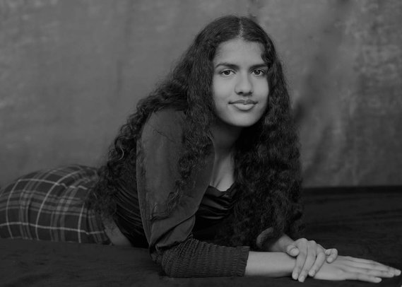 Studio portrait of a teenage girl with long curly black hair 