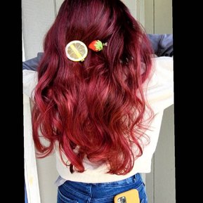 red hair with berry tones jean pants and a yellow phone case and strawberry and lemon clips