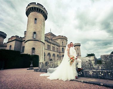 Wedding Photograph of couple at Eastnor Castle with the castle in the background by Robin Sandry of Sandry Studio Worcester UK professional photographer white suit and white dress