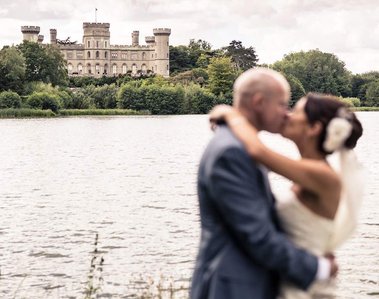 Wedding Photograph of couple at Eastnor Castle by the lake with the castle in the background by Robin Sandry of Sandry Studio Worcester UK professional photographer