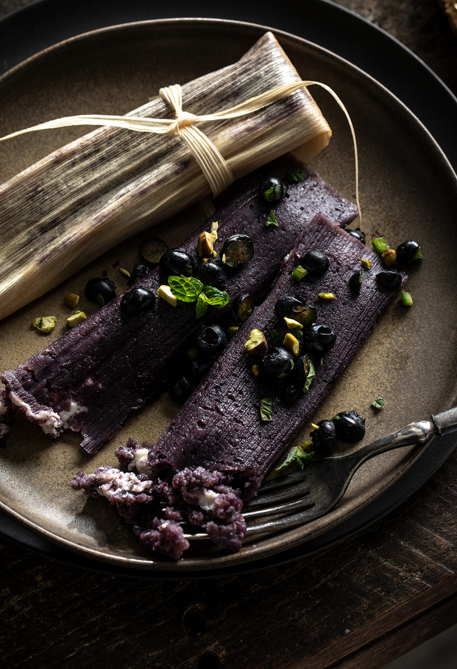 Dark and moody branding photography for Blueberry Council  with blueberry and cream cheese tamales on stacked plates.