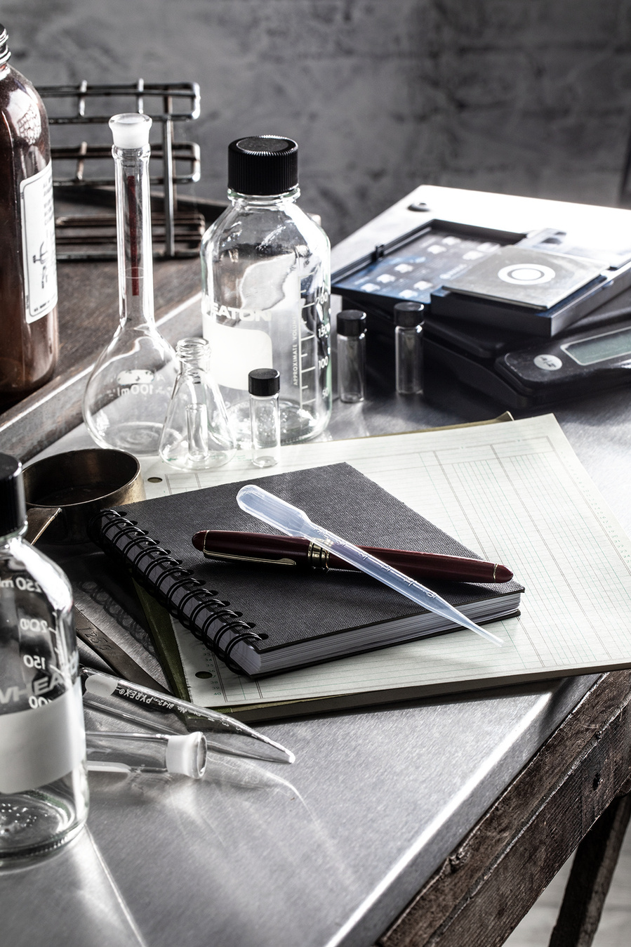 Scientific glassware, measuring instruments, and notepads and paper on a stainless steel counter. Materials needed for recipe development for the images of blueberries for the blueberry council. 