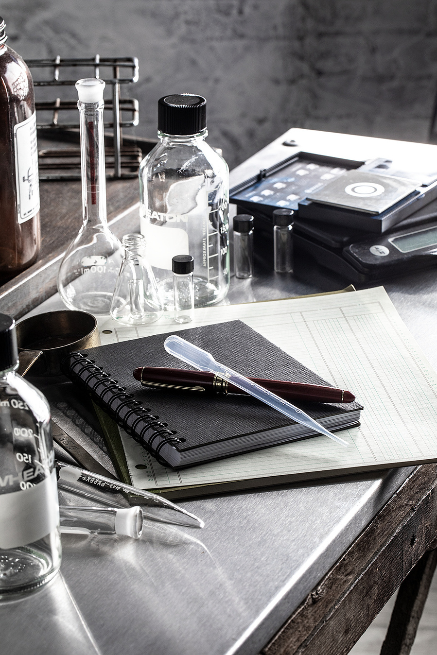 Scientific glassware, measuring instruments, and notepads and paper on a stainless steel counter. Materials needed for recipe development for the images of blueberries for the blueberry council. 