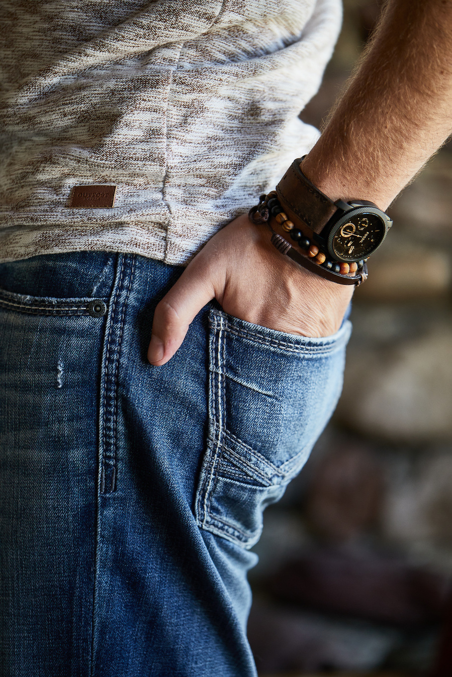 Man's hand in the back pocket of his jeans, showing off watch and bracelet for lifestyle fashion photography