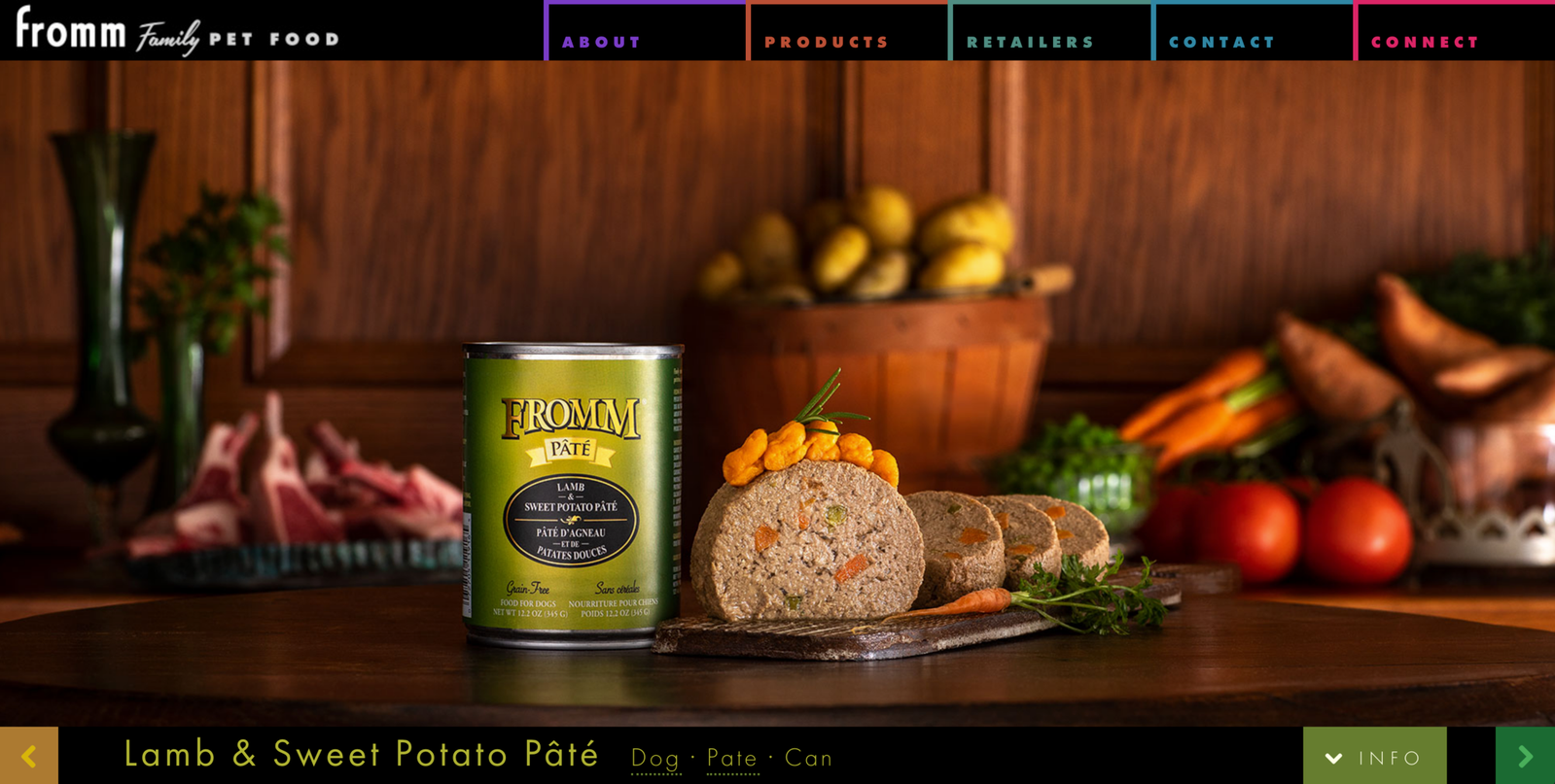 Canned food picture with can and loaf of dog food artfully plated and fresh meat and produce in the background. Website banner for Fromm Family Foods